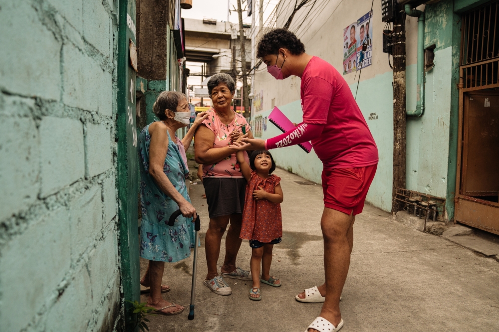 A supporter of Leni Robredo, the vice president of the Philippines who is running for president, during a door-to-door campaign for her, in Manila, April 8, 2022. (Hannah Reyes Morales/The New York Times)