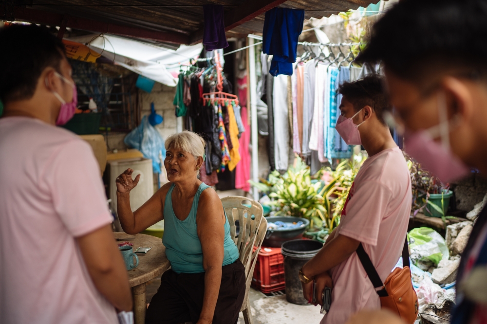 A supporter of Ferdinand Marcos Jr., the only son of the late dictator and a presidential candidate, debates volunteers for the campaign for Leni Robredo, the vice president of the Philippines who is running for president, in Valenzuela City, April 12, 2022. (Hannah Reyes Morales/The New York Times)