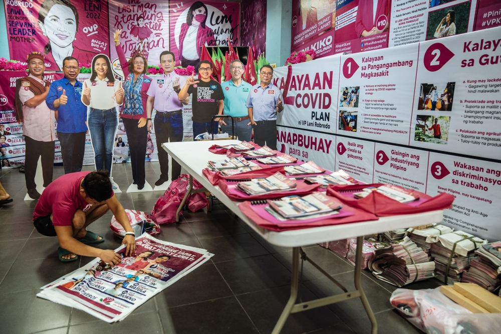 A supporter of Leni Robredo, the vice president of the Philippines who is running for president, prepares campaign literature, in Manila, April 8, 2022. (Hannah Reyes Morales/The New York Times)