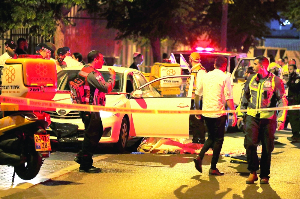 Israeli police and medics are pictured at the scene of an attack in the central city of Elad, on Thursday. -  AFP