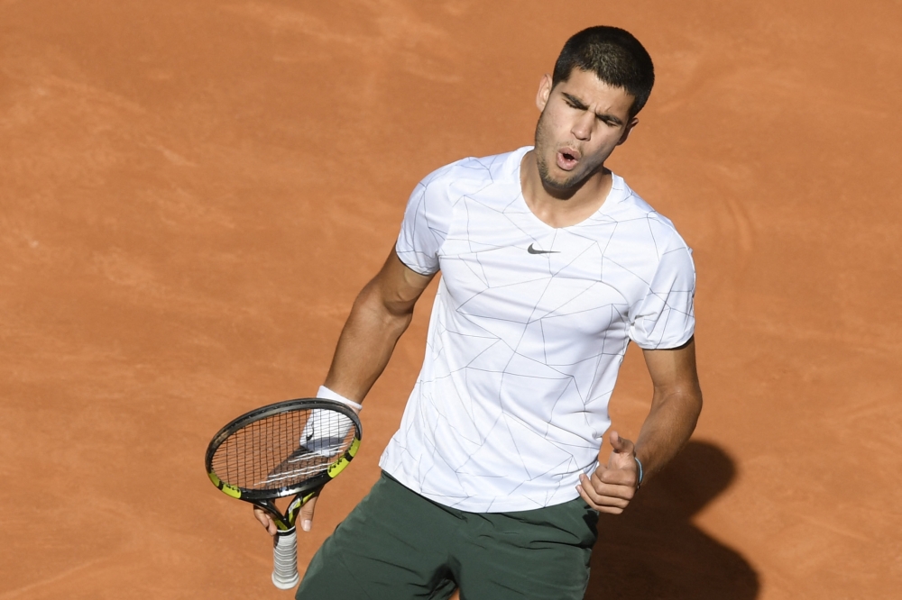 Spain's Carlos Alcaraz reacts as he competes against Spain's Rafael Nadal during their 2022 ATP Tour Madrid Open quarterfinal at the Caja Magica in Madrid. -- AFP
