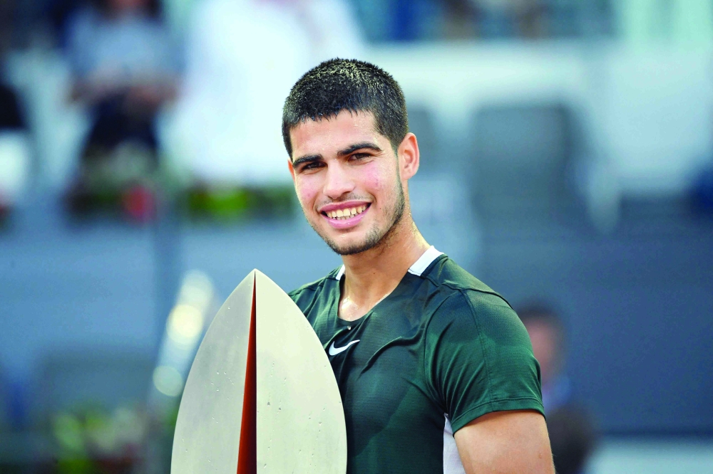 TOPSHOT - Spain's Carlos Alcaraz celebrates with the trophy after winning the 2022 ATP Tour Madrid Open tennis tournament men's singles final match against Germany's Alexander Zverev at the Caja Magica in Madrid on May 8, 2022. (Photo by OSCAR DEL POZO / AFP)


