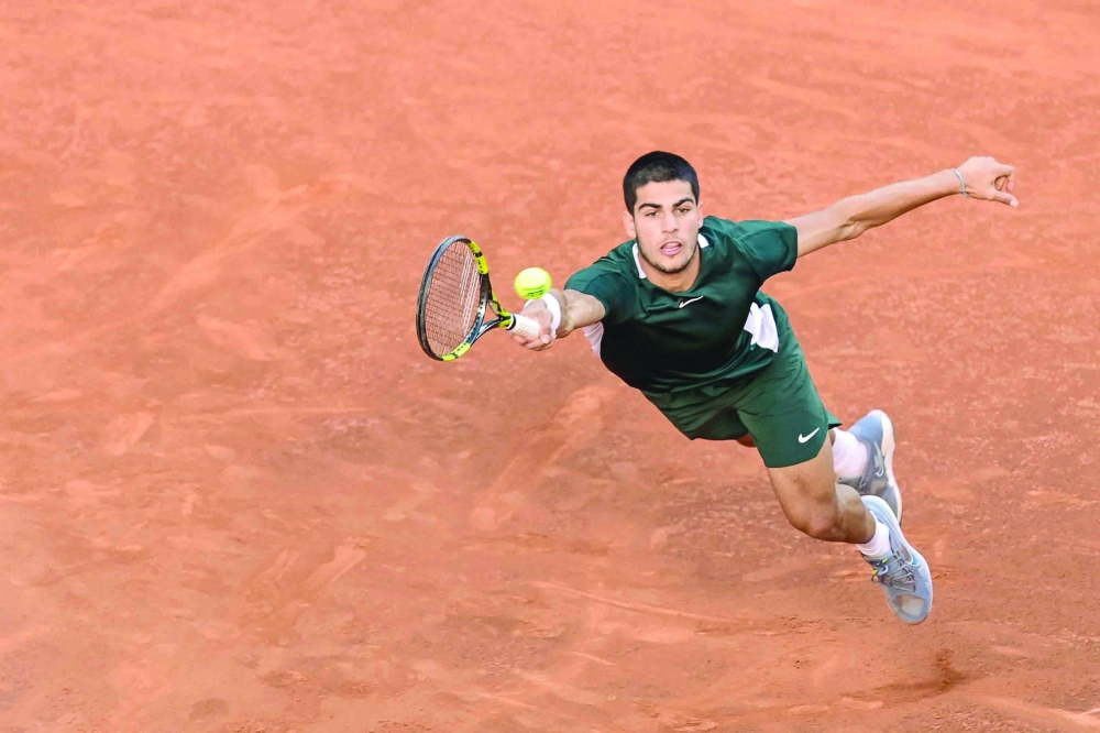 TOPSHOT - Spain's Carlos Alcaraz returns the ball to Germany's Alexander Zverev during their 2022 ATP Tour Madrid Open tennis tournament men's singles final match at the Caja Magica in Madrid on May 8, 2022. (Photo by JAVIER SORIANO / AFP)

