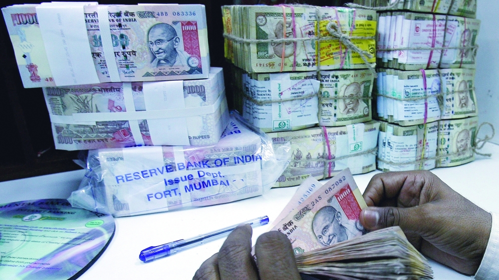 A bank employee counts rupee currency notes in Mumbai. — AFP