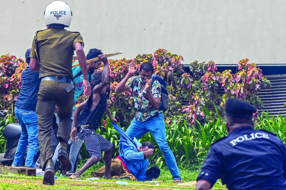 Demonstrators and government supporters clash outside the official residence of Sri Lanka's Prime Minister Mahinda Rajapaksa in Colombo. - AFP