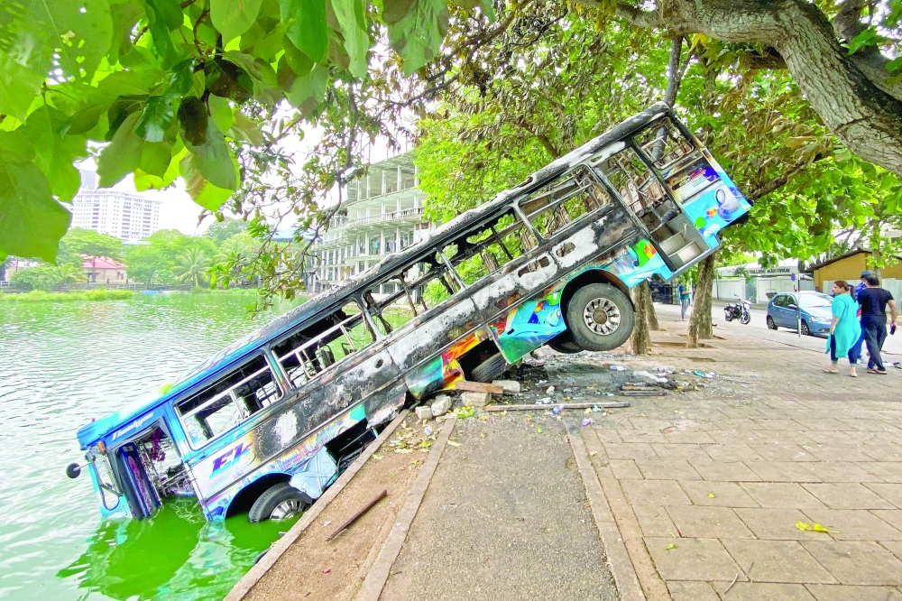 A burnt bus near Sri Lanka's former prime minister Mahinda Rajapaksa's official residence, a day after it was torched by protesters in Colombo. - AFP