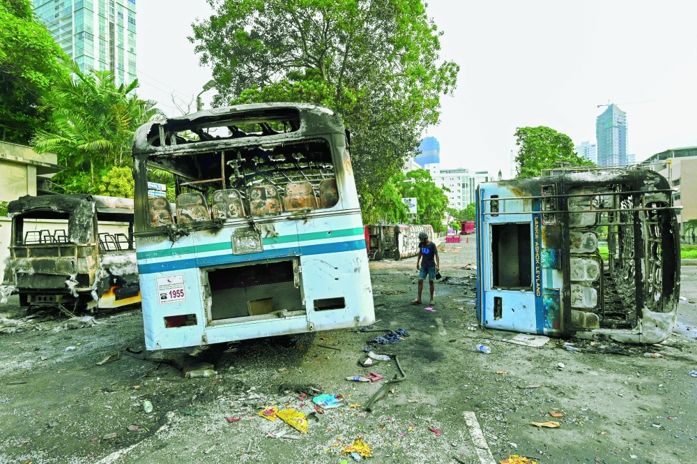 Burnt buses can be seen near Sri Lanka's former prime minister Mahinda Rajapaksa's official residence 'Temple Trees', in Colombo. - AFP