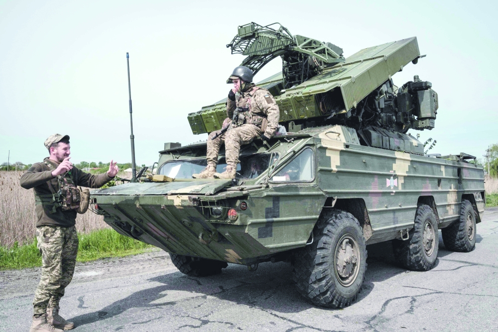 Ukrainian soldiers gesture around their anti aircraft missile system near Sloviansk, eastern Ukraine, amid the Russian war of Ukraine. - AFP
