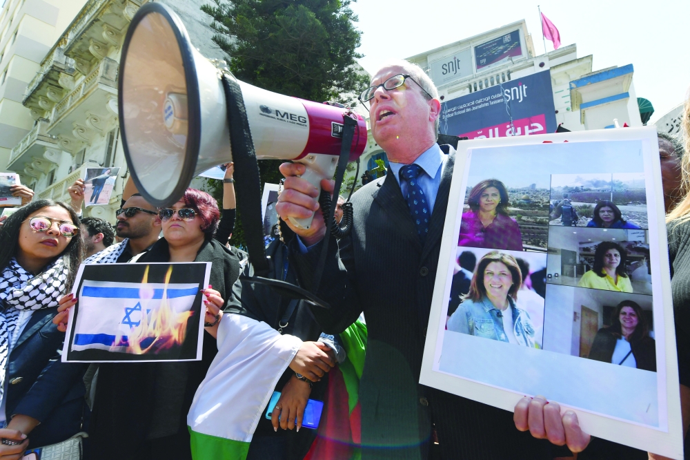 Tunisian journalists protest the death of veteran Al Jazeera Palestinian journalist Shireen Abu Akleh, who was killed while covering clashes in West Bank, outside the SNJT national journalists' union in Tunis.   — AFP