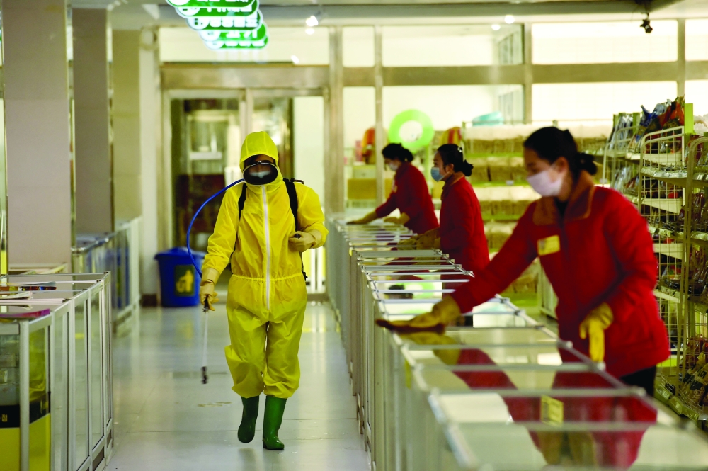 In this file photo taken on March 18 employees spray disinfectant and wipe surfaces as part of preventative measures against Covid-19 at the Pyongyang Children's Department Store in Pyongyan. - AFP 
