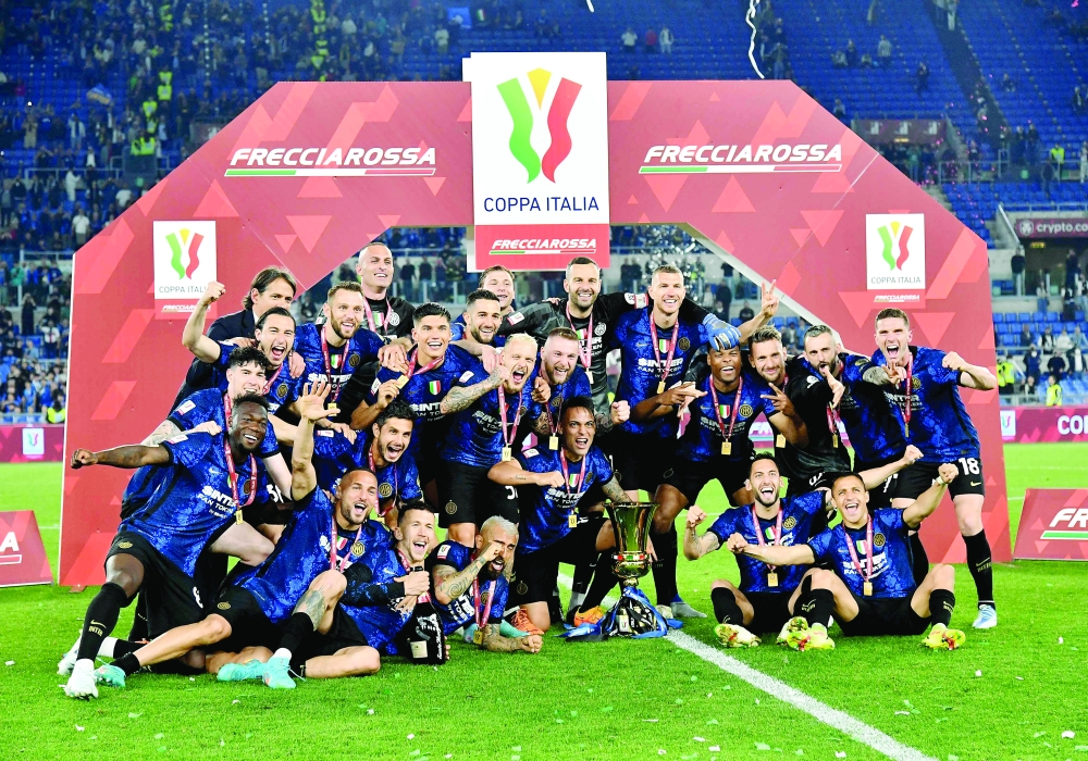 Inter Milan's Argentine forward Lautaro Martinez (C) and Inter players celebrate with the winner's trophy after Inter won the Italian Cup (Coppa Italia) final football match between Juventus and Inter on May 11, 2022 at the Olympic stadium in Rome. (Photo by Isabella BONOTTO / AFP)

