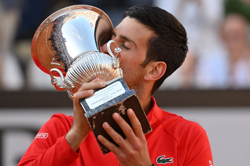 Serbia's Novak Djokovic kisses the winner's trophy after winning the final match of the Men's ATP Rome Open tennis tournament against Greece's Stefanos Tsitsipas on May 15, 2022 at Foro Italico in Rome. (Photo by Andreas SOLARO / AFP)

