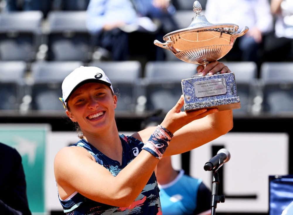 Poland's Iga Swiatek poses with the winner's trophy after defeating Tunisia's Ons Jabeur to win the final of the Women's WTA Rome Open tennis tournament on May 15, 2022 at Foro Italico in Rome. (Photo by Tiziana FABI / AFP)

