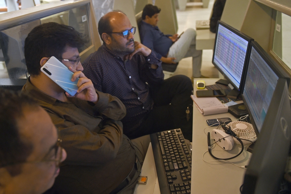 Stockbrokers monitor the share prices during a trading session at the Pakistan Stock Exchange (PSX) in Karachi on May 16, 2022. 