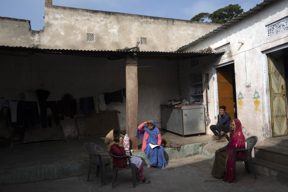 Bhanwar Bai Jadoun, 38, center, an accredited social healthcare activist, speaks with local women in Bagdoli, India, on Feb. 10, 2022.  (Saumya Khandelwal/The New York Times)