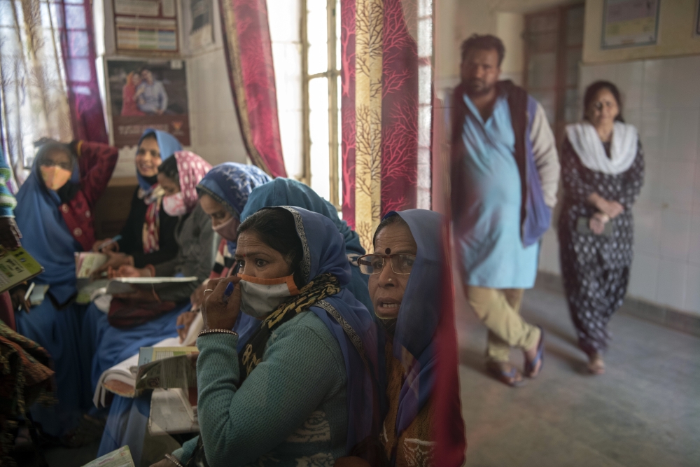 Health workers wait with mothers and children who are being immunized at a community health center in Bonli, India, on Feb. 10, 2022.  (Saumya Khandelwal/The New York Times)
