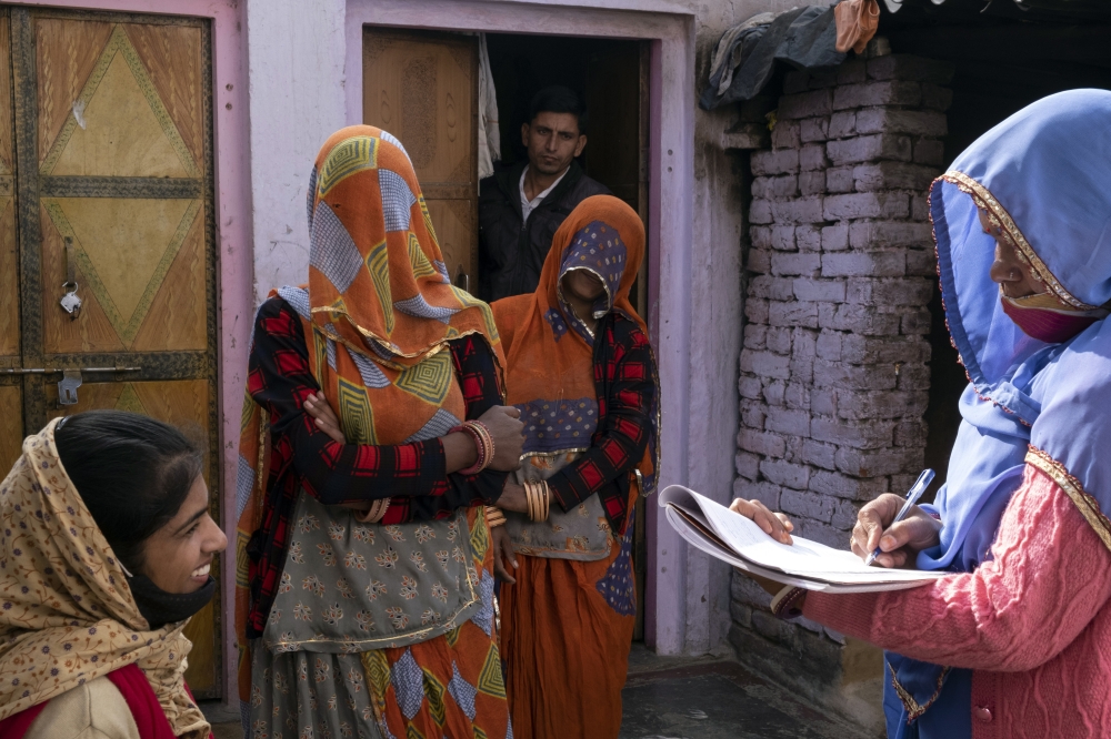 Bhanwar Bai Jadoun, right, an accredited social healthcare activist, and Anita Chowdhary, left, update records of childrens immunization in Bagdoli, India, on Feb. 10, 2022.  (Saumya Khandelwal/The New York Times)