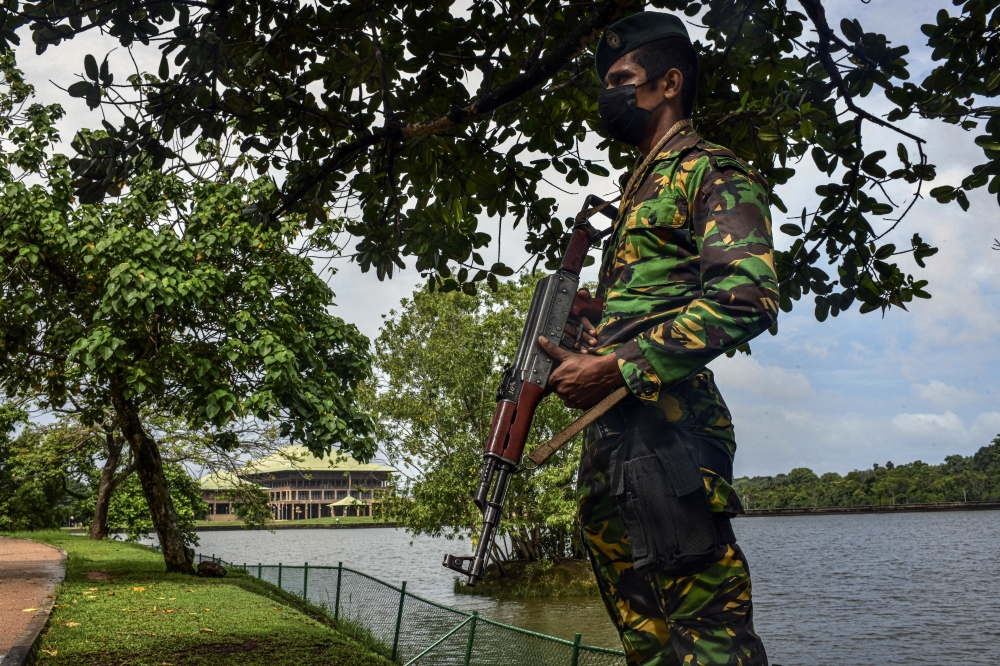 A guard near the Parliament building in Colombo, Sri Lanka, on Tuesday, May 17, 2022.  (Atul Loke/The New York Times)