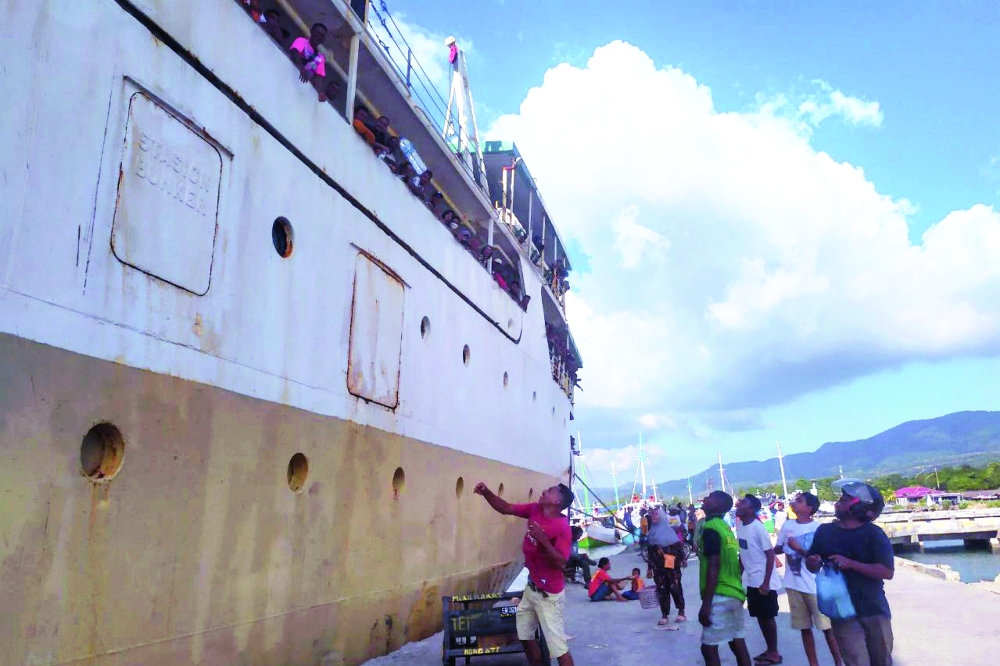 Food and beverage vendors toss their wares to passengers onboard the KM Sirimau ferry that was towed to port in Lembata Island on Thursday. - AFP 