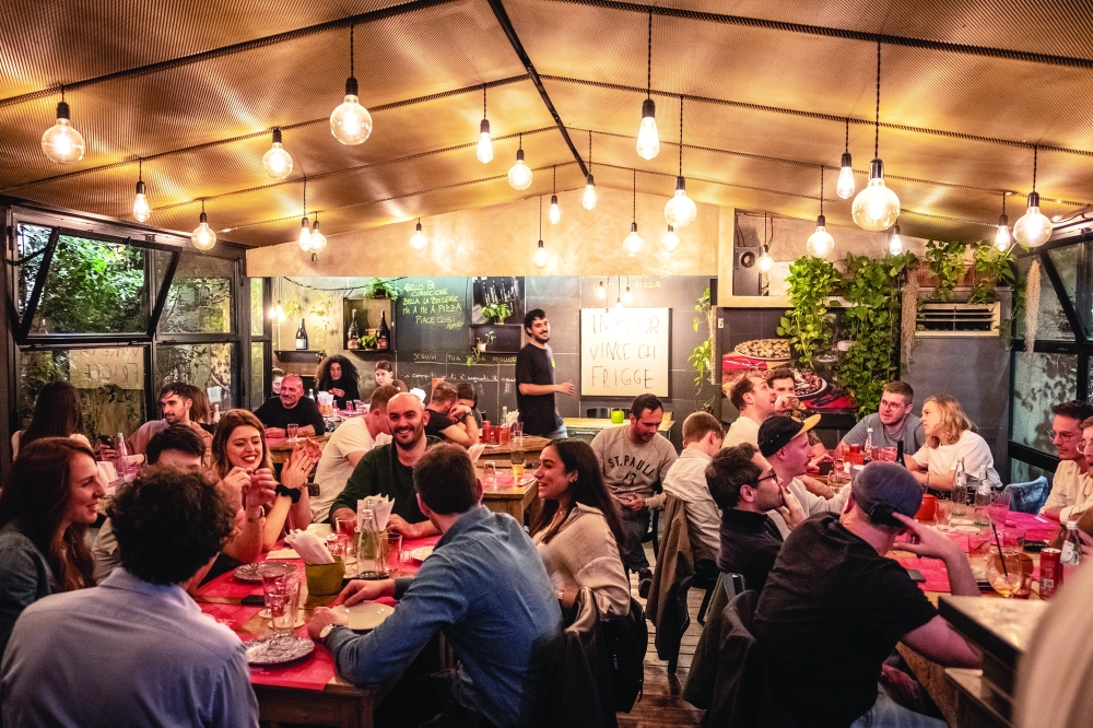 Diners at the new Pizzeria LElementare, which serves up thin-crust pizzas and craft beers, in Rome, May 5, 2022. (Francesco Lastrucci/The New York Times)