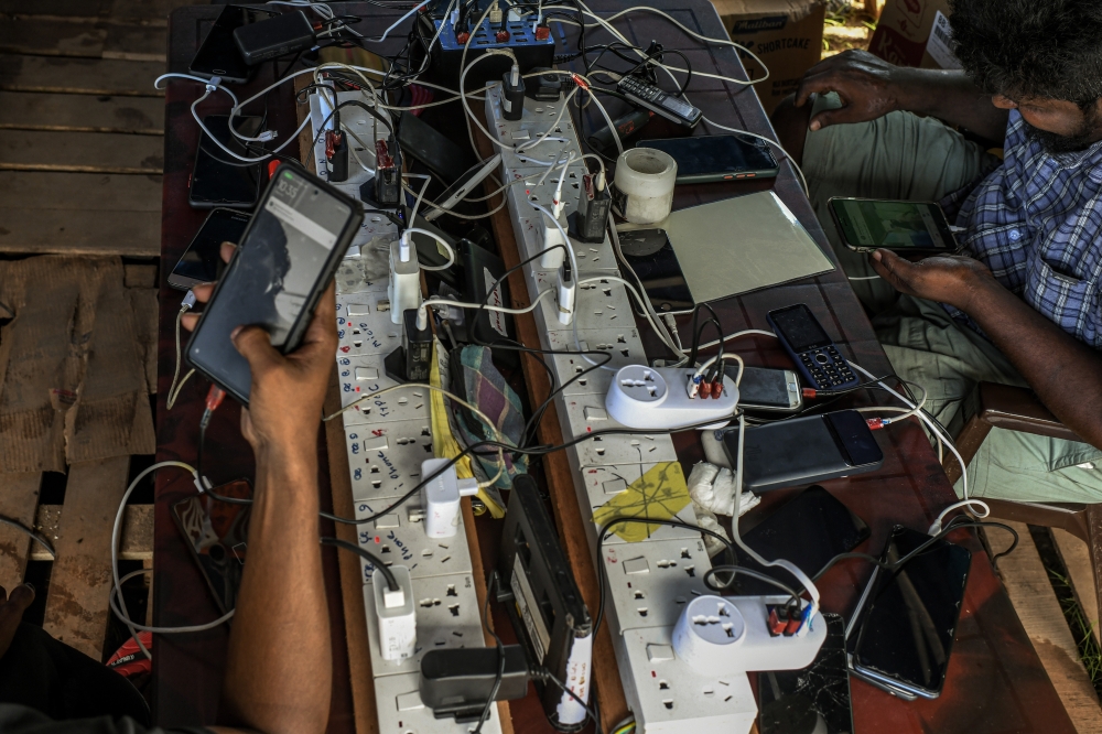 Demonstrators charge their phones at the “Gota Go” protest village in Colombo, Sri Lanka, May 20, 2022. (Atul Loke/The New York Times)