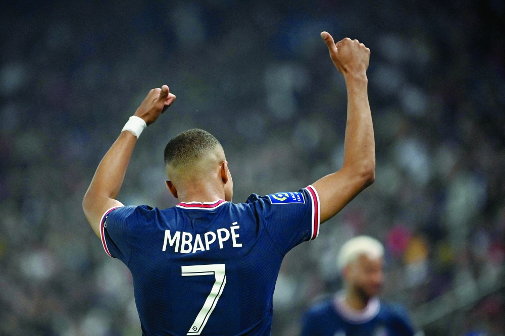 TOPSHOT - Paris Saint-Germain's French forward Kylian Mbappe celebrates after scoring a third goal during the French L1 football match between Paris Saint-Germain (PSG) and Metz at the Parc des Princes stadium in Paris on May 21, 2022. (Photo by Anne-Christine POUJOULAT / AFP)

