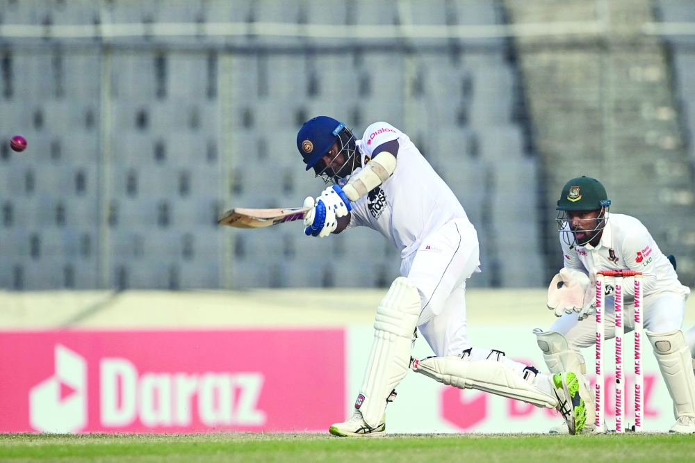 Sri Lanka's Angelo Mathews (L) plays a shot as Bangladesh's wicketkeeper Liton Das watches during the third day of the second Test cricket match between Bangladesh and Sri Lanka at the Sher-e-Bangla National Cricket Stadium in Dhaka on May 25, 2022. (Photo by Munir uz ZAMAN / AFP)