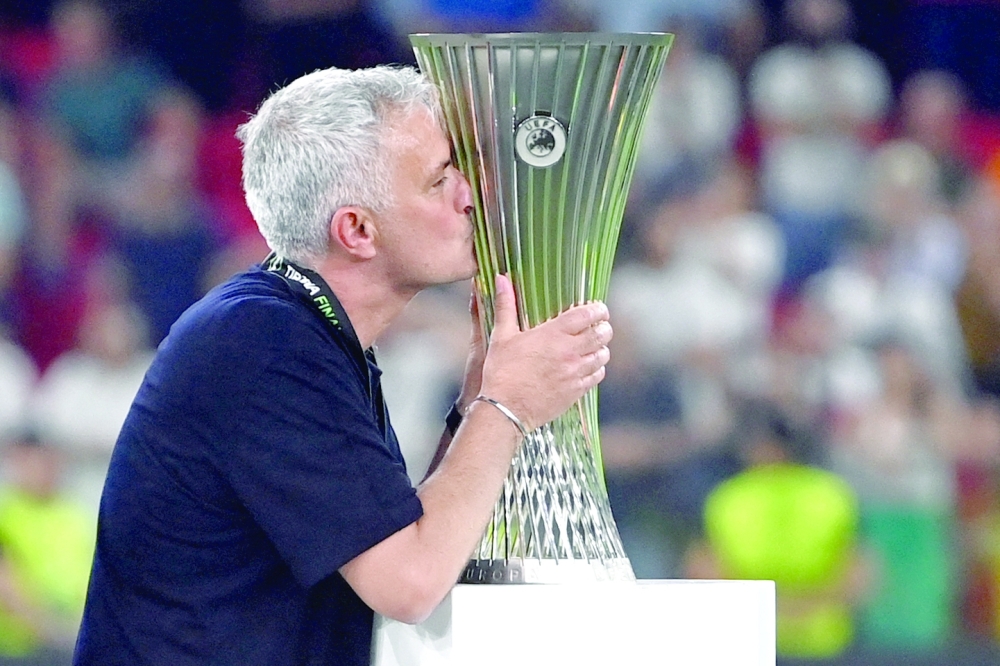Roma's Portuguese head coach Jose Mourinho kisses the trophy as his team celebrates winning the UEFA Europa Conference League final football match between AS Roma and Feyenoord at the Air Albania Stadium in Tirana on May 25, 2022. (Photo by OZAN KOSE / AFP)

