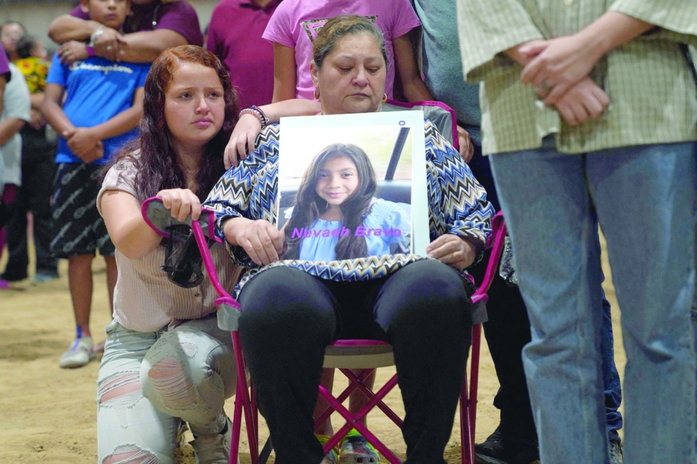 A woman holds a photo of Nevaeh Bravo, who was killed in the mass shooting, during a vigil for the victims of the mass shooting at Robb Elementary School in Uvalde, Texas. - AFP
