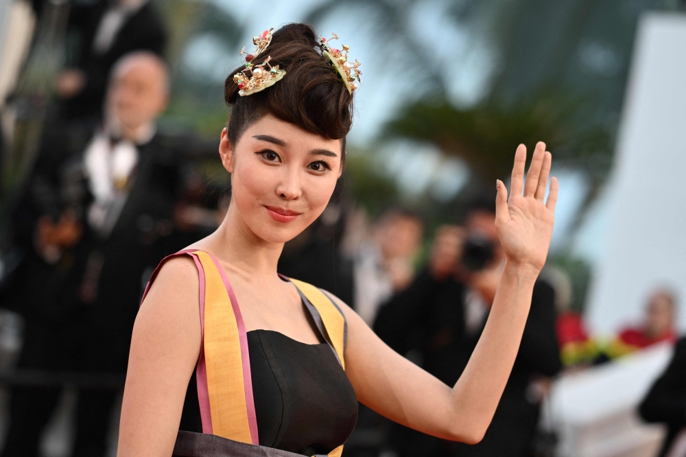 A guest arrives for the screening of the film "Mascarade" during the 75th edition of the Cannes Film Festival in Cannes, southern France, on May 27, 2022. 