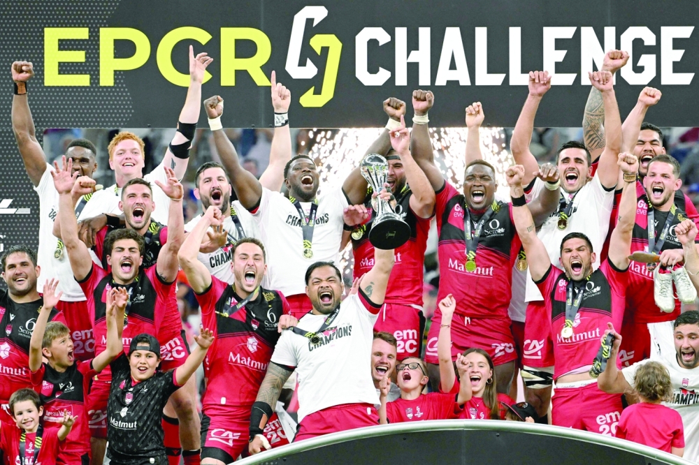 TOPSHOT - Lyon's players celebrate with the trophy after winning the European Challenge Cup rugby union final match between Lyon Olympique Universitaire (LOU) and Rugby Club Toulonnais (RCT) at the Velodrome Stadium in Marseille, southeastern France, on May 27, 2022.  (Photo by Pascal GUYOT / AFP)

