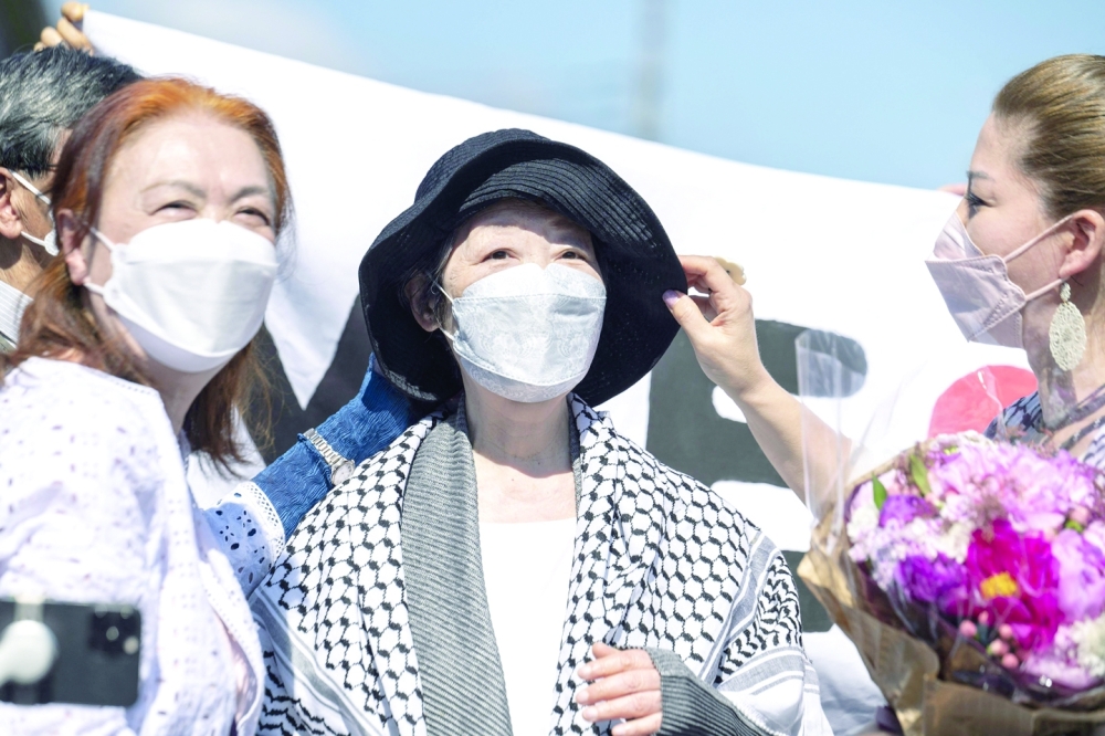 Fusako Shigenobu (C) after her release from jail, flanked by her daughter May Shigenobu (R) and her lawyer (L) talks to journalists in Akishima, Tokyo prefecture on Wednesday. - AFP

