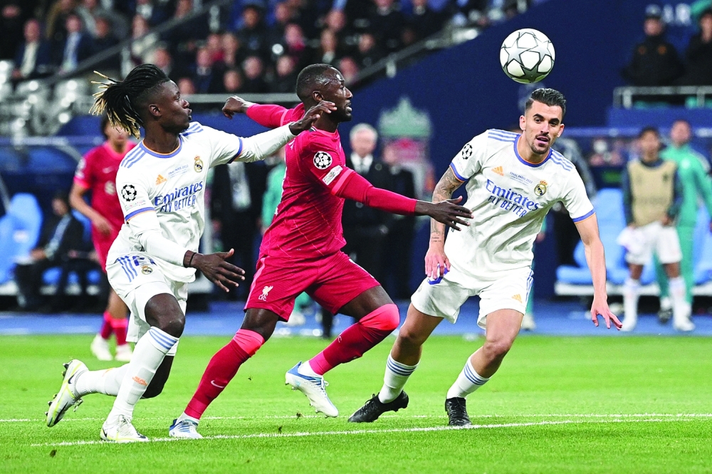 Liverpool's Guinean midfielder Naby Keita (C) fights for the ball with Real Madrid's Angolan midfielder Eduardo Camavinga (L) and Real Madrid's Spanish midfielder Daniel Cebellos (R) during the UEFA Champions League final football match between Liverpool and Real Madrid at the Stade de France in Saint-Denis, north of Paris, on May 28, 2022.  (Photo by Anne-Christine POUJOULAT / AFP)

