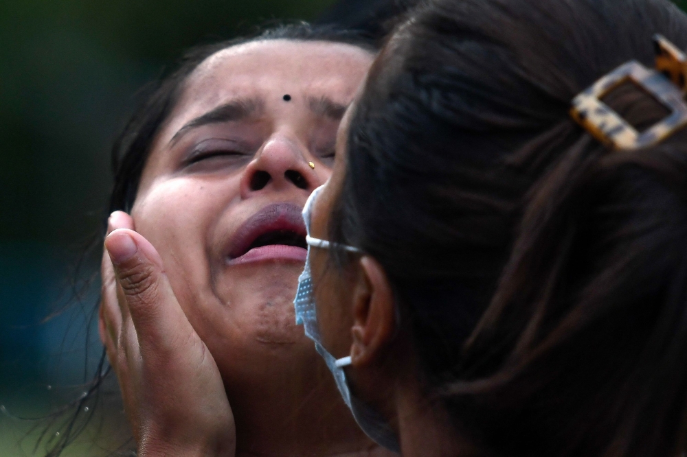 Family members and relatives of passengers on board the Twin Otter aircraft operated by Tara Air, weep outside the airport in Pokhara on May 29, 2022. 