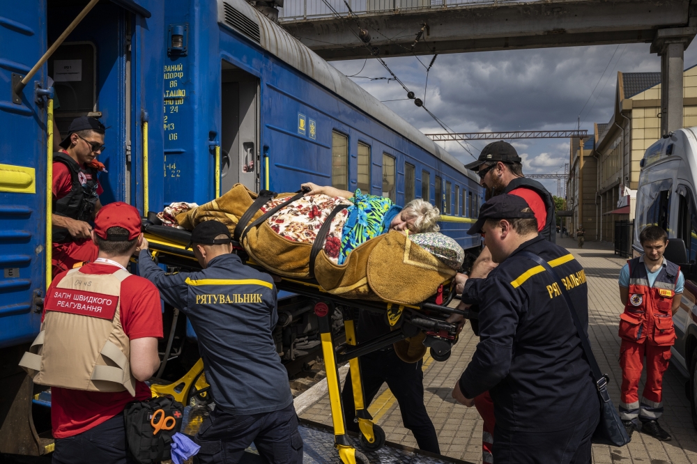 Civilians are assisted onto a medical evacuation train in Pokrovsk, Ukraine, on Sunday, May 29, 2022. (Ivor Prickett/The New York Times)