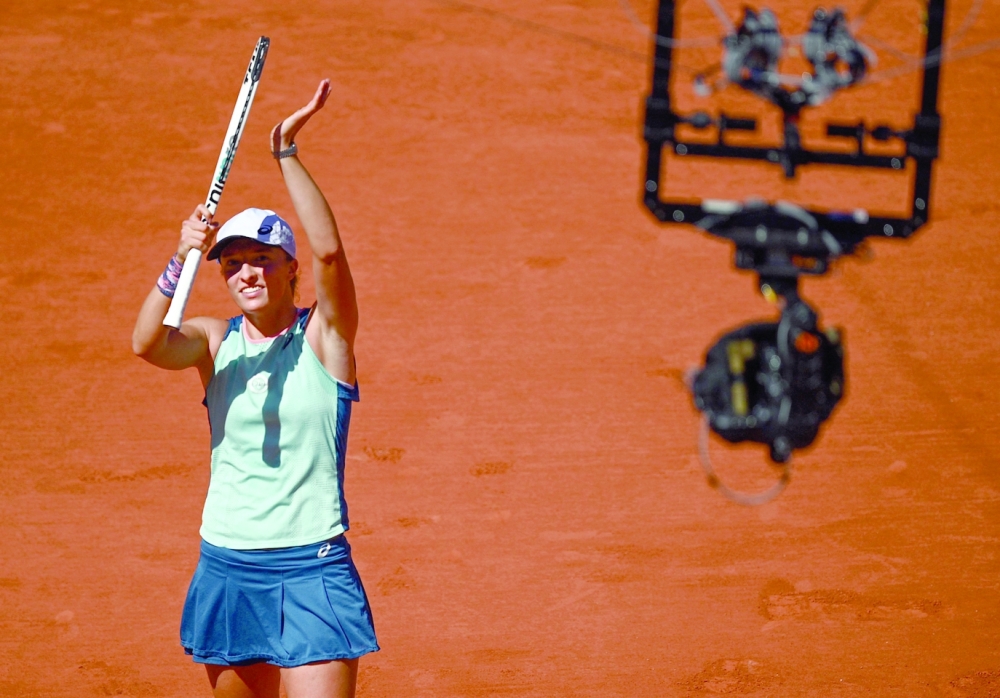 Poland's Iga Swiatek celebrates after victory over Russia's Darya Kasatkina in their women's semifinal singles match on day twelve of the Roland-Garros Open tennis tournament at the Court Philippe-Chatrier in Paris on June 2, 2022. (Photo by Christophe ARCHAMBAULT / AFP)