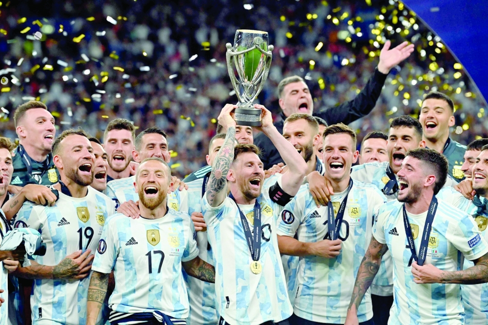 TOPSHOT - Argentina's striker Lionel Messi lifts the trophy as Argentina's players celebrate on the pitch after their victory in the 'Finalissima' International friendly football match between Italy and Argentina at Wembley Stadium in London on June 1, 2022. The Azzurri face the South American continental champions in the inaugural Finalissima at Wembley. (Photo by Glyn KIRK / AFP)