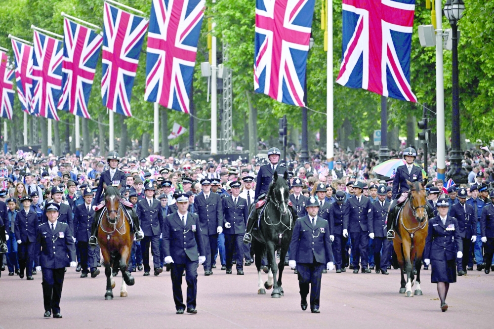 British Police leads members of the public down The Mall towards Buckingham Palace at the end of the Queen's Birthday Parade. 
