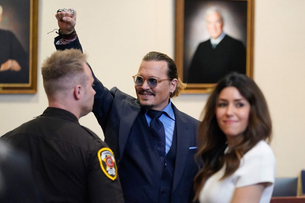 Actor Johnny Depp gestures to spectators in court after closing arguments at the Fairfax County Circuit Courthouse in Fairfax, Virginia, on May 27, 2022.   Actor Johnny Depp is suing ex-wife Amber Heard for libel after she wrote an op-ed piece in The Washington Post in 2018 referring to herself as a “public figure representing domestic abuse.”  (Photo by Steve Helber / POOL / AFP)