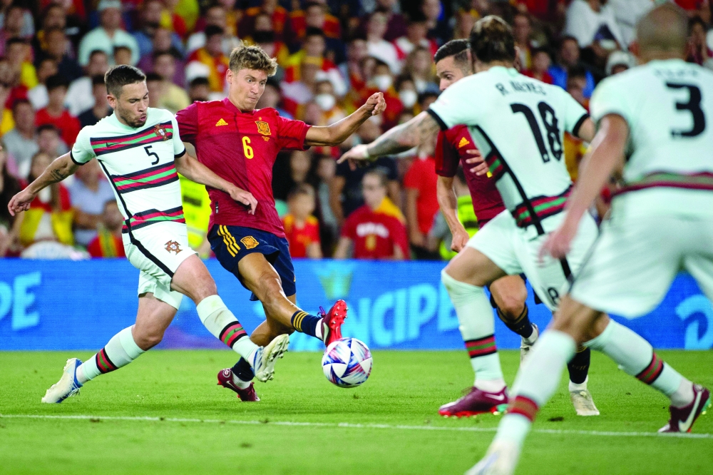 Portugal's defender Raphael Guerreiro (L) vies with Spain's midfielder Marcos Llorente. -- AFP