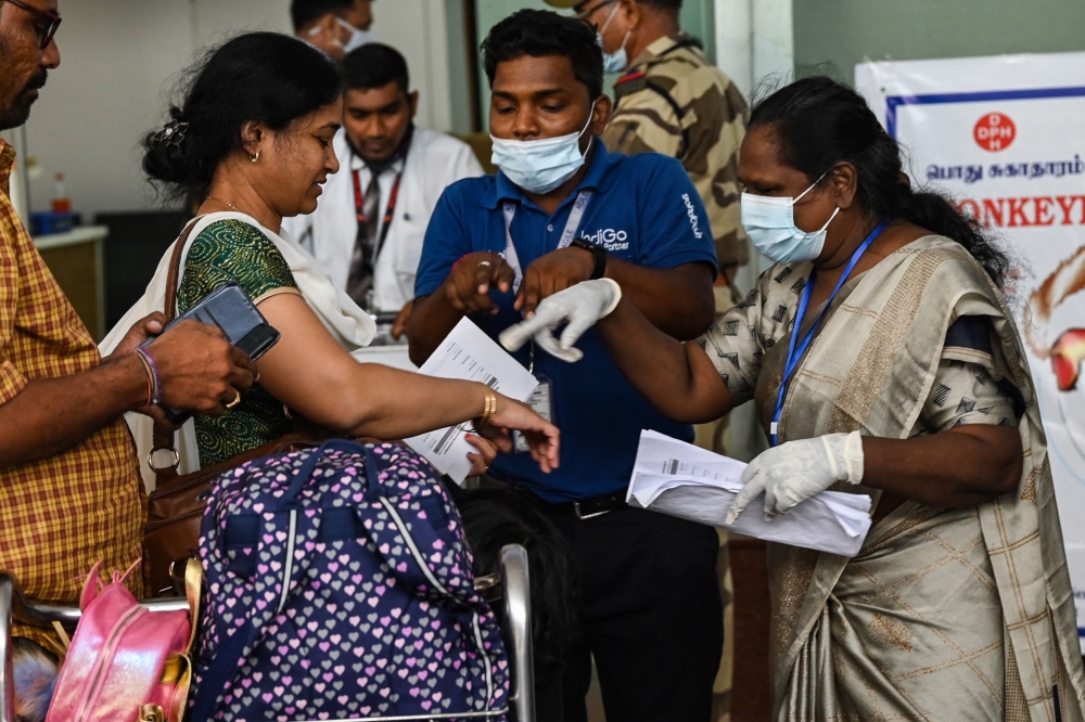 Health workers screen passengers arriving from abroad for Monkeypox symptoms at Anna International Airport terminal in Chennai on June 03, 2022.