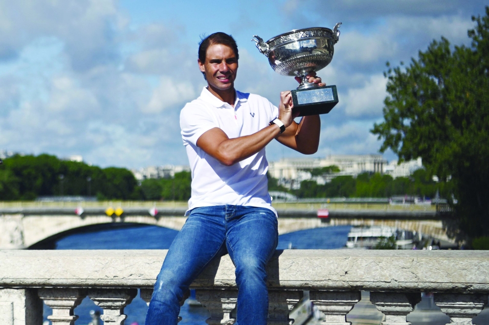 Spain's Rafael Nadal poses with the trophy on Alexandre III bridge, a day after his 14th victory at the Roland-Garros Open tennis tournament in Paris on June 6, 2022. Rafael Nadal, 36, won a 14th French Open with daily pain-killing injections in his troublesome left foot and will now attempt to find a permanent cure for the injury, warning his record-breaking career is on the line. (Photo by Christophe ARCHAMBAULT / AFP)

