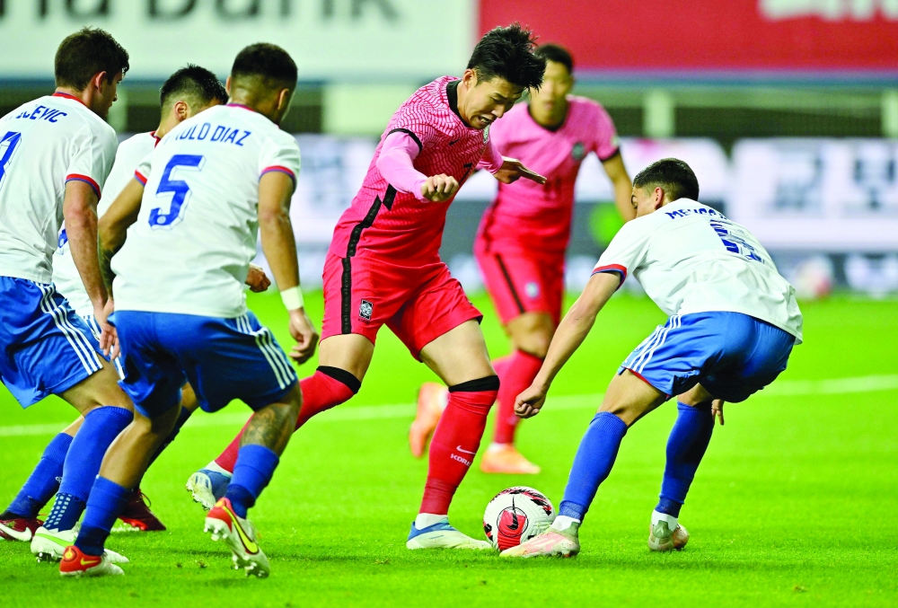 South Korea's Son Heung-min (C) dribbles the ball against Chile during a friendly football match between South Korea and Chile in Daejeon on June 6, 2022. (Photo by Jung Yeon-je / AFP)