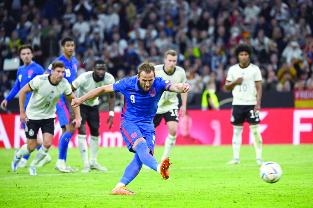 England's forward Harry Kane shoots from the penalty spot to score his team's equaliser during the UEFA Nations League football match Germany v England in Munich, southern Germany on June 7, 2022.  (Photo by Tobias SCHWARZ / AFP)