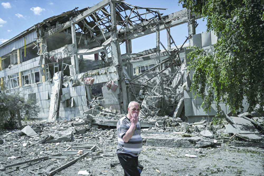 A local resident reacts in front of a destroyed school after a strike in the city of Bakhmut, eastern Ukrainian region of Donbas. - AFP
