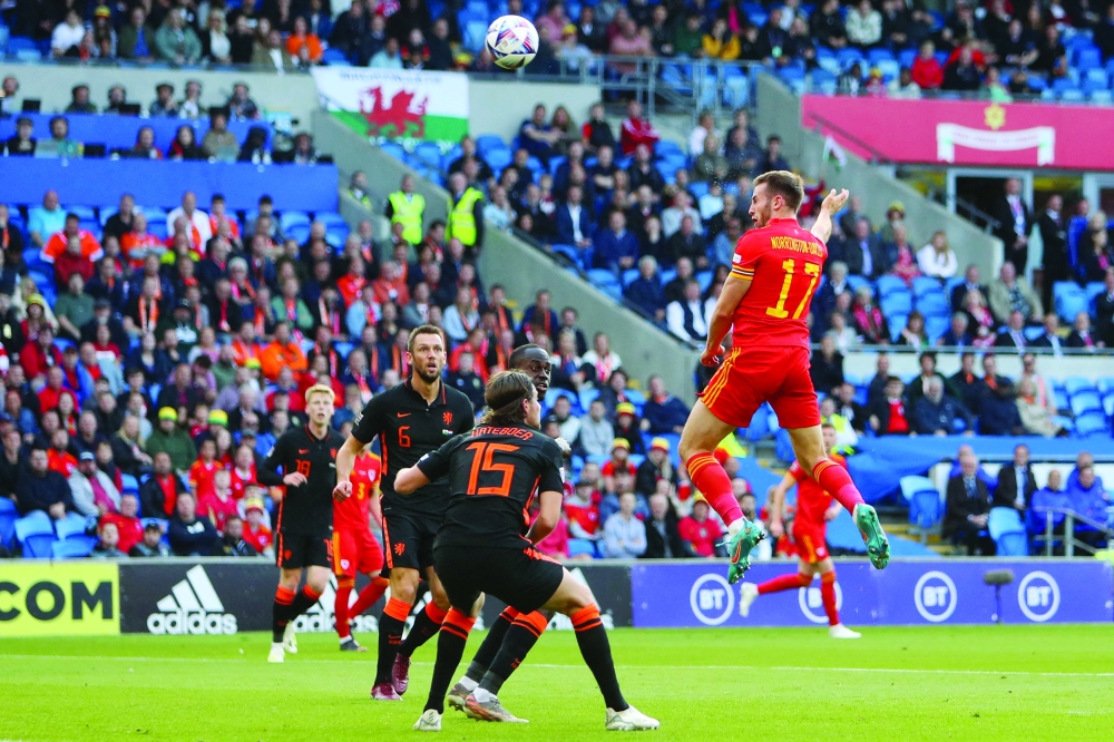 Wales' defender Rhys Norrington-Davies (R) heads this attempt over the bar during the UEFA Nations League, league A group 4 football match between Wales and Netherlands at Cardiff City stadium in Cardiff, south Wales on June 8, 2022.   (Photo by Geoff Caddick / AFP)

