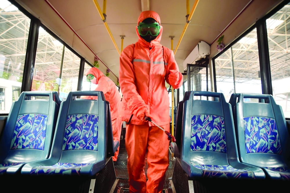 Health officials of the Ryonmot Trolley Bus Office disinfect a trolley bus, as part of preventative measures against Covid-19 in Pyongyang on Thursday. - AFP


