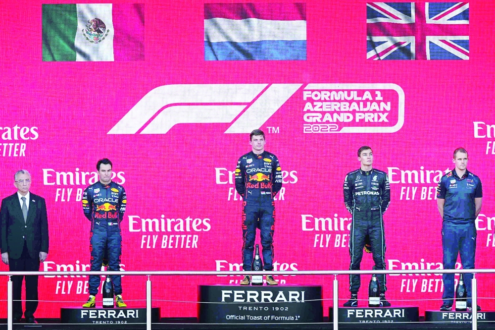 Second placed Red Bull's Mexican driver Sergio Perez, winner Red Bull's Dutch driver Max Verstappen and third placed Mercedes' British driver George Russell celebrate on the podium after the Formula One Azerbaijan Grand Prix at the Baku City Circuit in Baku. — AFP
