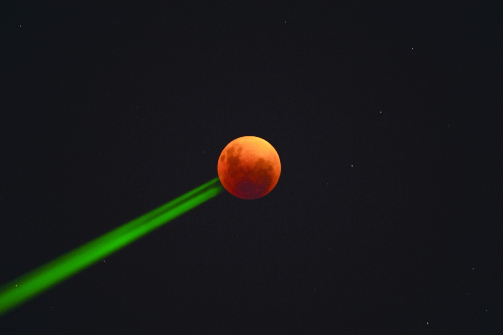 The blood moon is seen during a total lunar eclipse in Santiago, Chile, on Sunday. - AFP
