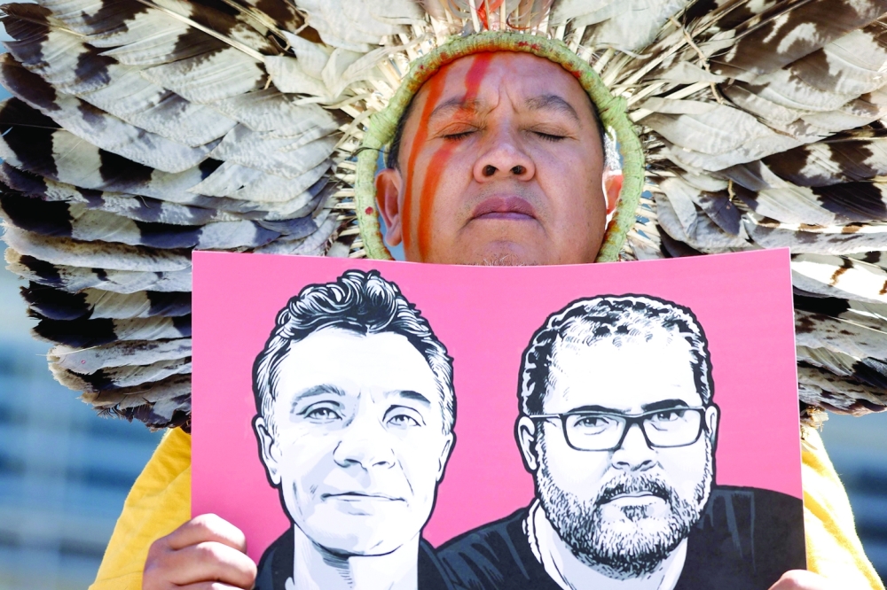 A member of the Articulation of Indigenous Peoples of Brazil (APIB) holds the image of UK journalist Dom Phillips and Brazilian Indigenous affairs specialist Bruno Pereira during a protest near the European Commission building in Brussel on Thursday. - AFP